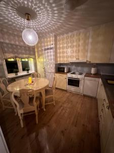 een keuken met een tafel en stoelen en een tafel en een licht bij Cozy guesthouse in Slussfors, Swedish Lapland in Slussfors