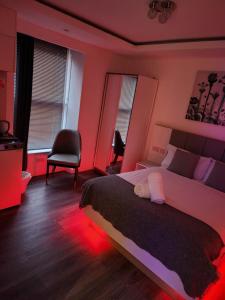 a bedroom with a large bed with red lights at Crosskeys Edinburgh in Edinburgh