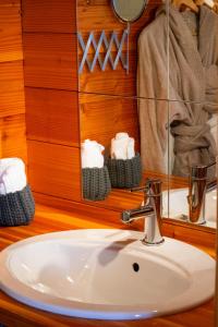 a sink in a bathroom with a mirror and towels at Chambres et table d'hôtes au chalet Datcha in Briançon