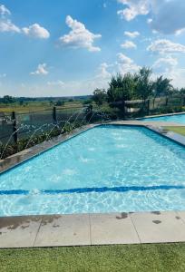 a large swimming pool with blue water at Lethabo Eco_Estate in Boksburg