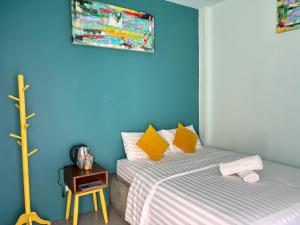 una camera da letto con pareti blu, un letto e un tavolo di The Huahin Hotel a Hua Hin