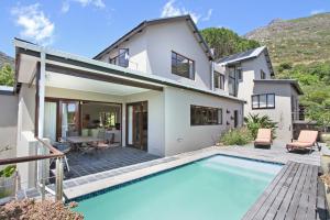 a villa with a swimming pool and a house at Villa Arena in Cape Town