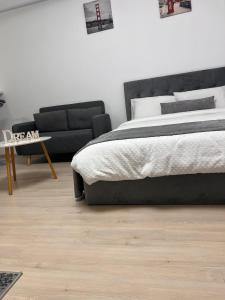 een slaapkamer met een bed en een bank bij Dream Studio in Sînpetru