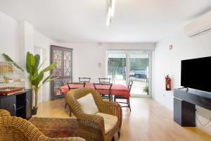 a living room with a table and chairs and a television at Quinta Moinhos da Tapada in Luso