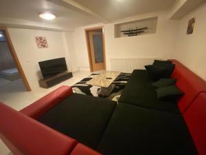 een woonkamer met een rode bank en een televisie bij Luka Central Apartment in Craiova
