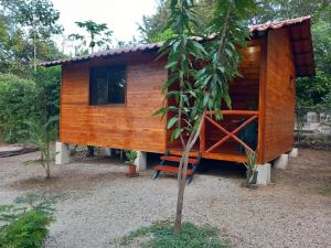 a wooden house with a tree at Aura Bungalow in Tamarindo