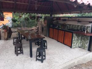 einen Holztisch und einige Stühle sowie eine Küche in der Unterkunft Aura Bungalow in Tamarindo