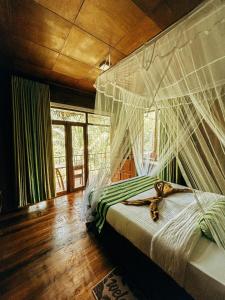 Un dormitorio con una cama con mosquiteros. en NatureWoodland en Ella