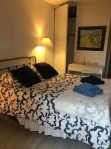 um quarto com uma cama com um edredão preto e branco em Chambre avec balcon et salle de bain privée em Paris
