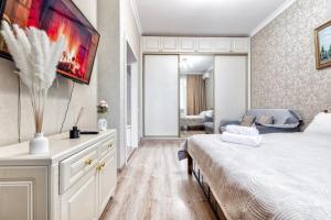 a bedroom with a bed and a painting on the wall at Однокомнатная элитная квартира в ЖК Expo Boulevard in Taldykolʼ