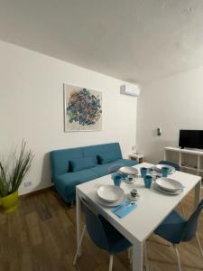 Ronago的住宿－B&B FIOR DI CAMPO，一张带蓝色椅子的白色桌子和一张蓝色的沙发