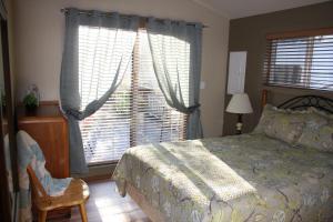 a bedroom with a bed and a large window at A Shack In The Woods in Port Renfrew