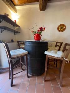 a wine barrel with chairs and a vase with flowers at Ca' Rosmunda in Bagnone
