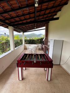una mesa de ping pong en medio de un balcón en Suíte em Miguel Pereira, en Miguel Pereira