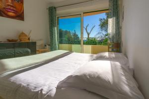 a bedroom with a bed and a large window at Appartement Vue mer, 2ch, 60m². in Théoule-sur-Mer