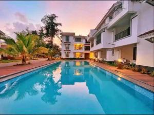 a swimming pool in front of a house at Riviera Sublime Holiday Homes in Siolim