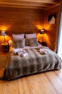 a bedroom with a large bed with towels on it at Chambres et table d'hôtes au chalet Datcha in Briançon