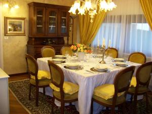 a dining room table with a white table cloth and chairs at Villa Graziella Perugia in Perugia