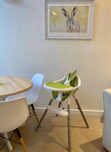 una sala da pranzo con tavolo e sedia con una pianta di WEE SUZIE STAYS - Stunning George St Apartment a Perth