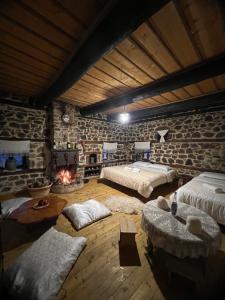 a large room with two beds and a fireplace at Kulla Hupi Agriturism in Bulqizë