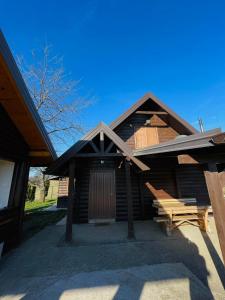 eine Blockhütte mit einem Gameradach und einer Veranda in der Unterkunft Family cottage Fairy tale in Banja Luka