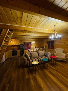 ein Wohnzimmer mit einem Sofa und einem Tisch in der Unterkunft Family cottage Fairy tale in Banja Luka