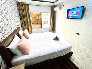 een slaapkamer met een groot bed en een televisie aan de muur bij Appartement centre-ville avec Wifi Fibre Optique in Fès