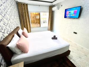 a bedroom with a large bed with a television on the wall at Appartement centre-ville avec Wifi 100 Mo in Fès