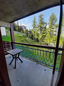 a balcony with a bench and a view of the water at Le RUITOR in Bourg-Saint-Maurice