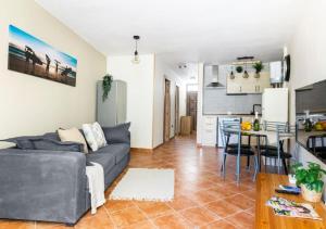 a living room with a gray couch and a kitchen at Cosy Apartment in Los Cristianos 5min to the ocean in Los Cristianos
