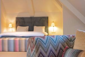 a hotel room with two beds and a couch at La Butte aux Bois in Lanaken