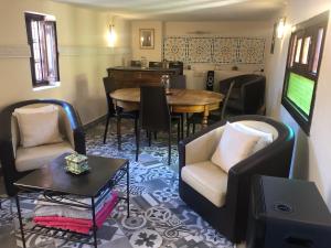 a living room with chairs and a table and a television at Riad Inaya Fez in Fez
