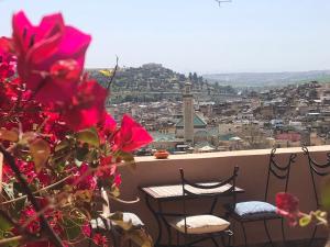 balcón con 2 sillas y vistas a la ciudad en Riad Inaya Fez en Fez