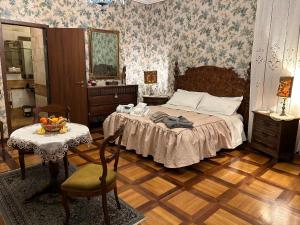 Villa Carla - Camera King Superior في بادوفا: غرفة نوم بسرير وطاولة مع كرسي