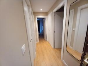 - un couloir dans un appartement doté de murs blancs et de parquet dans l'établissement Altissim Apartments, au Pas de la Case
