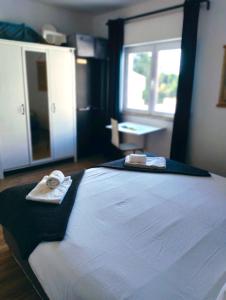 a bedroom with a large bed with two towels on it at Casa Nikolina in Albufeira