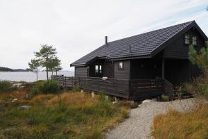 une cabine noire sur la rive d'un lac dans l'établissement Magical Seaview and close to Preikestolen, à Strand