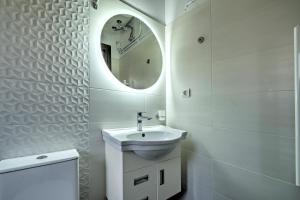 a white bathroom with a sink and a mirror at Διαμέρισμα στο Κέντρο Ναυπλίου in Nafplio