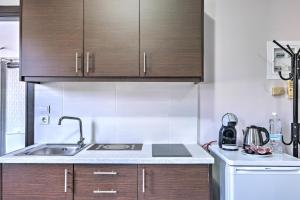 eine Küche mit Holzschränken und einem Waschbecken in der Unterkunft Διαμέρισμα στο Κέντρο Ναυπλίου in Nafplio