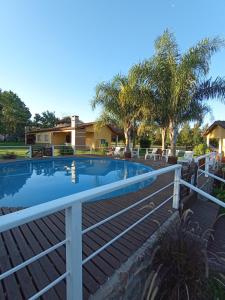 a swimming pool with a white rail next to a house at Bungalows El Zarateno in Colón