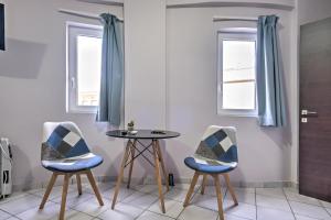 Zimmer mit 2 Stühlen und einem Tisch in der Unterkunft Διαμέρισμα στο Κέντρο Ναυπλίου in Nafplio