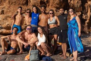 a group of people posing for a picture on the beach at Mabidi Surf Camp Morocco in Taghazout