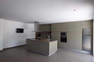 a large kitchen with a counter and a refrigerator at Quinta de Jaco in Vieira do Minho