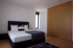 ヴィエイラ・ド・ミーニョにあるQuinta de Jacoのベッドルーム1室(大型ベッド1台、木製キャビネット付)