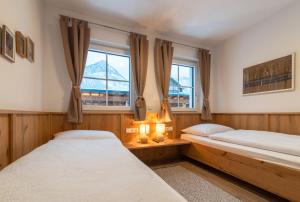 two beds in a room with two windows at Villa Elisabeth in Strobl