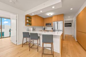 a kitchen with wooden cabinets and a counter with stools at Sky Ala Moana 4209 condo in Honolulu