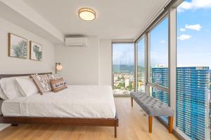 a bedroom with a bed and large windows at Sky Ala Moana 4209 condo in Honolulu