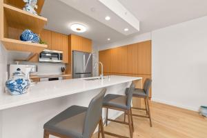 a kitchen with a counter with chairs and a sink at Sky Ala Moana 4209 condo in Honolulu
