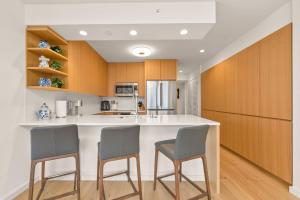 a kitchen with a large white island with two chairs at Sky Ala Moana 4209 condo in Honolulu