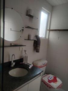 a bathroom with a sink and a mirror and a toilet at Veredas do bosque in Curitiba